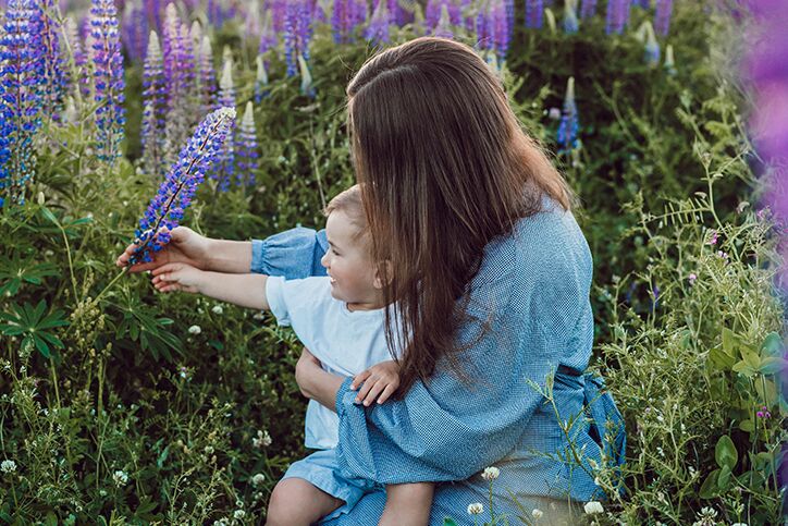 A mom and her child picking purple flowers