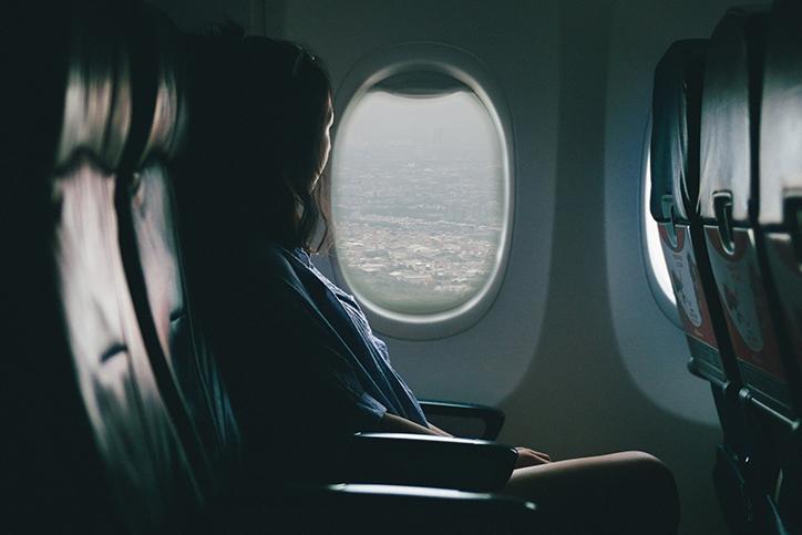 A woman staring out a plane window