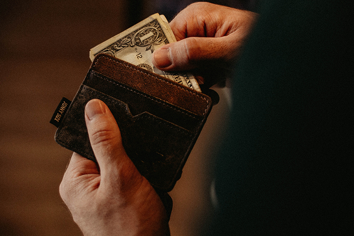 A man pulling cash out of his wallet
