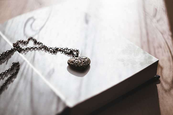 A metal locket laying on a book