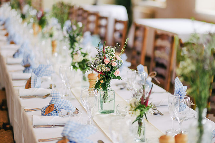 A long table set with dinnerware and flowers
