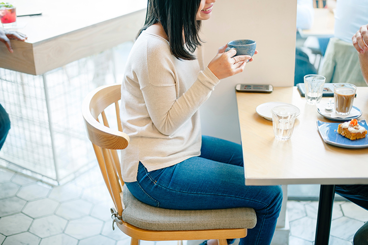 A woman drinking a cup of coffee in a cafe