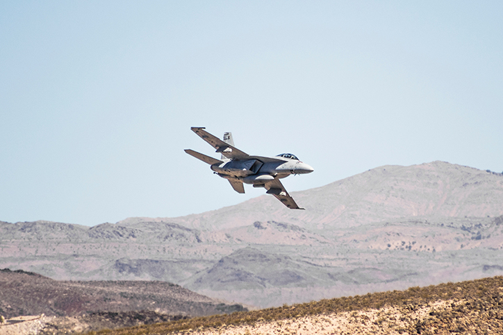 A military plane flying in the desert