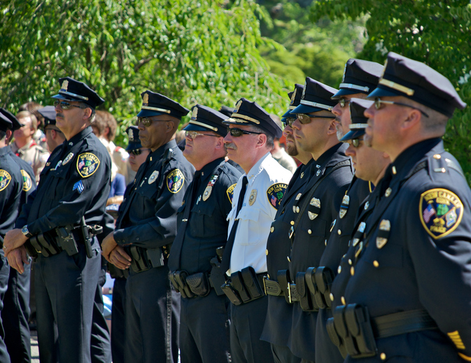 Police Officers stand at a memorial service.