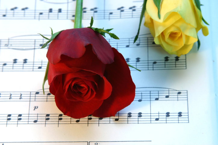 Yellow and Red rose on top of funeral music notes
