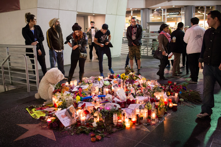 People gather around a memorial for David Bowie