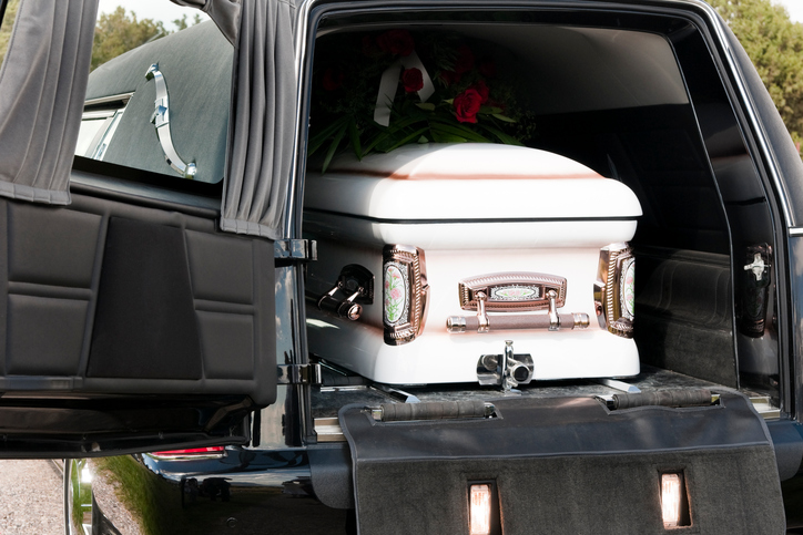 A casket sits in the back of a hearse