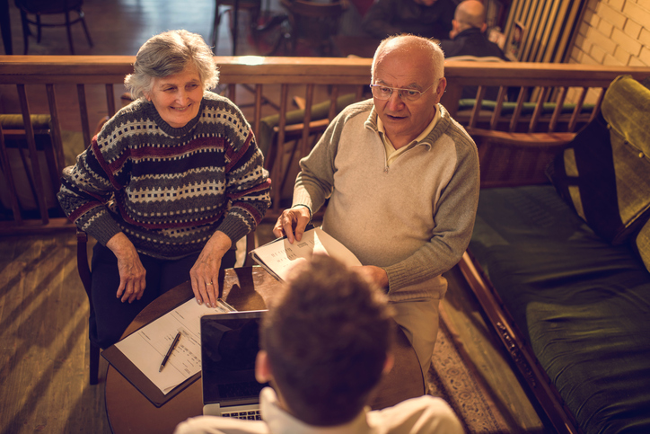 An older couple talks to an adviser