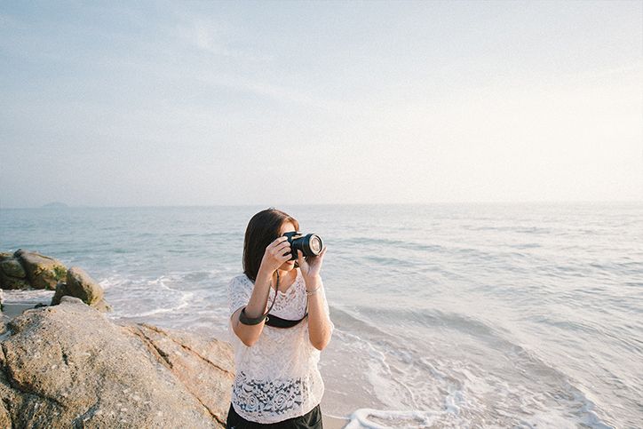A woman taking pictures at the beach