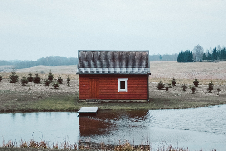A red shed next to a pond