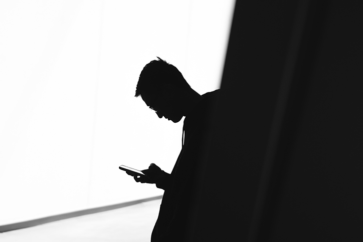 black and white photo of a man looking at his phone