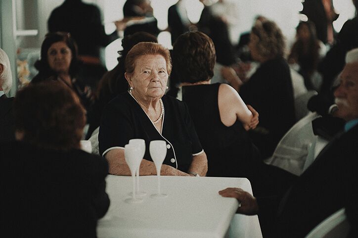 An elderly woman wearing black and sitting at a table