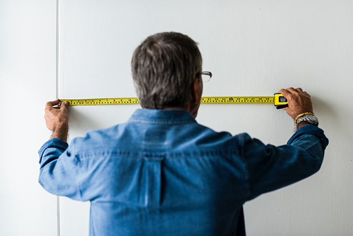 man measuring wall