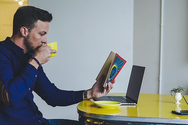 man reading and drinking coffee