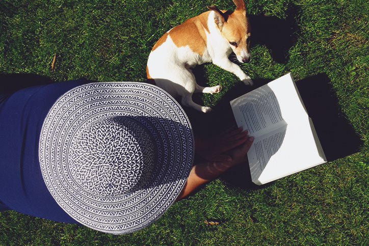 woman reading outside with her dog
