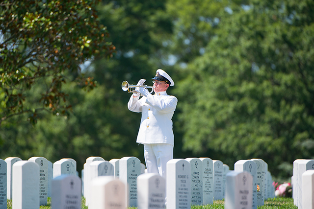 military man playing bugle