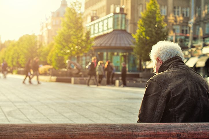 Older man sitting on a bench outside