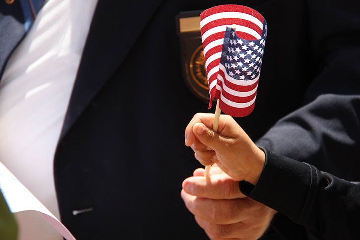 Older veteran handing an American flag to a child