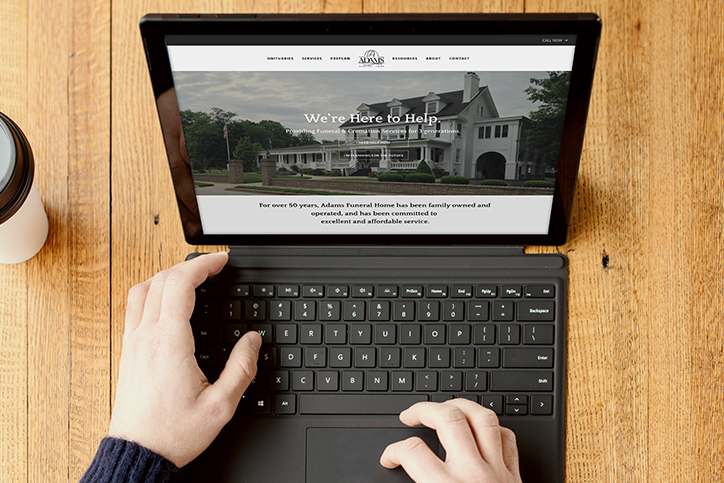 Adams Funeral Home website on a laptop